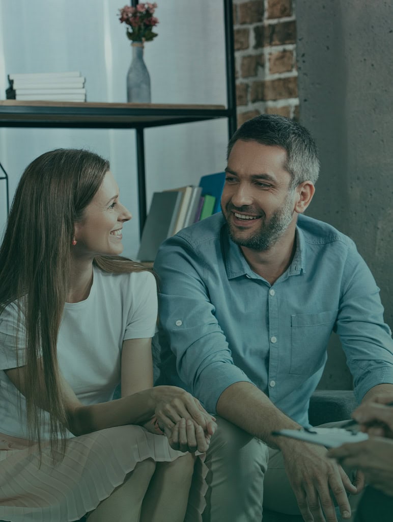 Family counseling session with a smiling therapist and client in a cozy office setting.