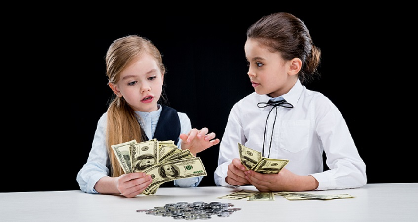 Two young girls dressed up in business attire counting fake money