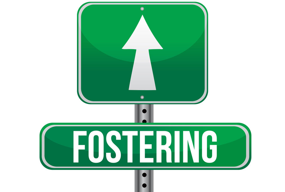 A street sign that says "Fostering Ahead"